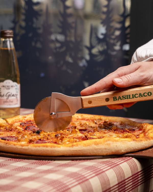 Pizza découpée avec une roulette Basilic & Co, contenu photo pour les réseaux sociaux